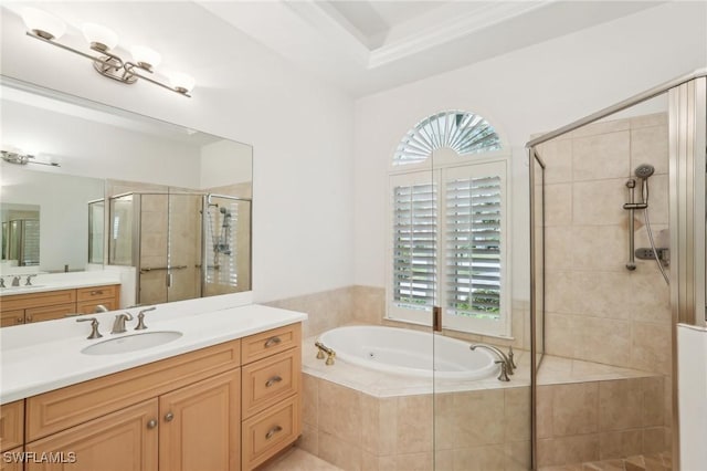 bathroom with a stall shower, a garden tub, and two vanities
