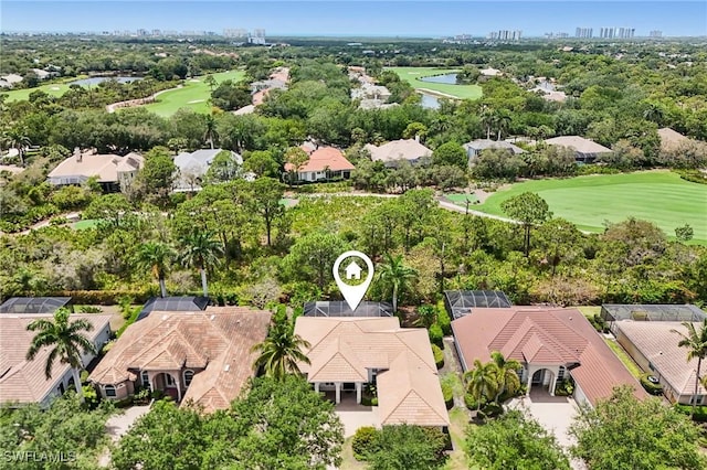 aerial view of residential area featuring a golf course, a large body of water, and a tree filled landscape