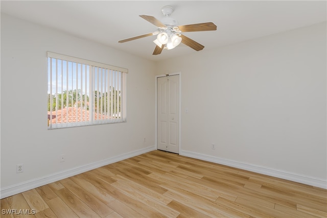 spare room with ceiling fan and light wood-type flooring