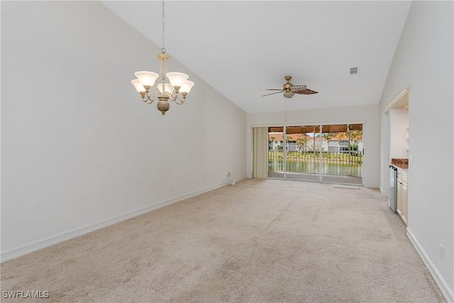 unfurnished living room with a water view, vaulted ceiling, light carpet, and ceiling fan with notable chandelier