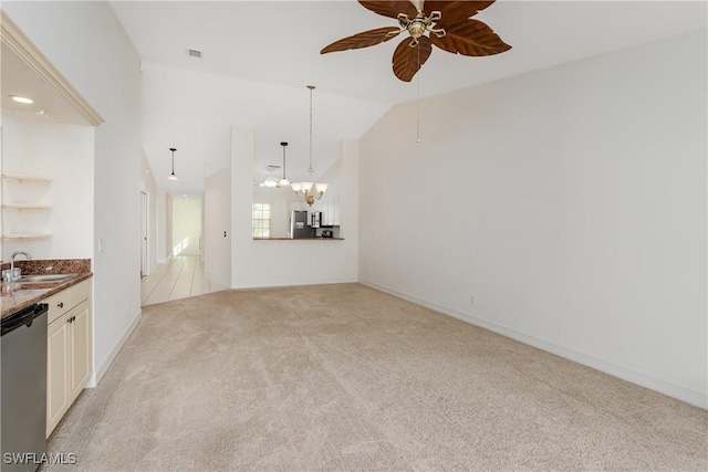 unfurnished living room featuring sink, ceiling fan with notable chandelier, light carpet, and vaulted ceiling