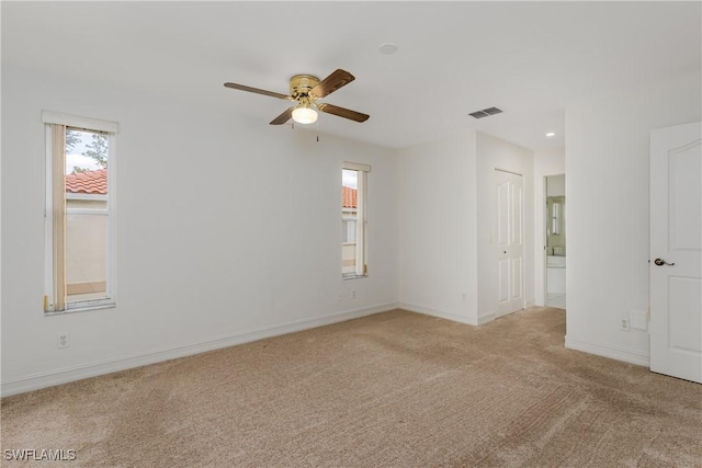 spare room with ceiling fan and light carpet