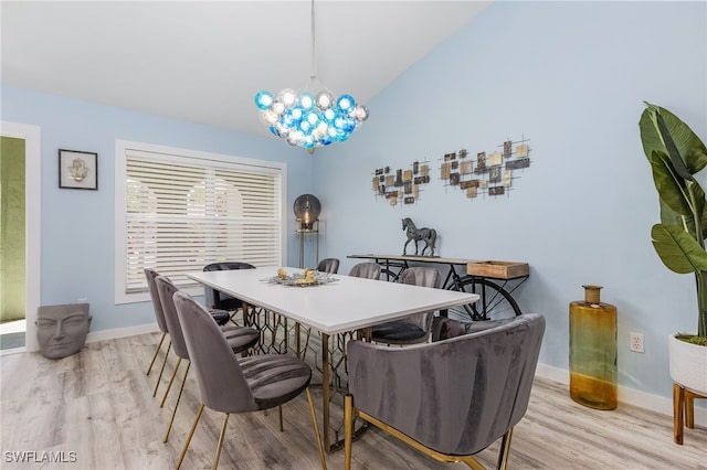 dining area featuring light wood-type flooring, vaulted ceiling, and a chandelier