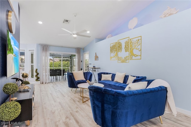 living room with light hardwood / wood-style flooring, ceiling fan, and high vaulted ceiling