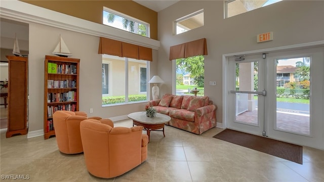 tiled living room with a healthy amount of sunlight and a towering ceiling