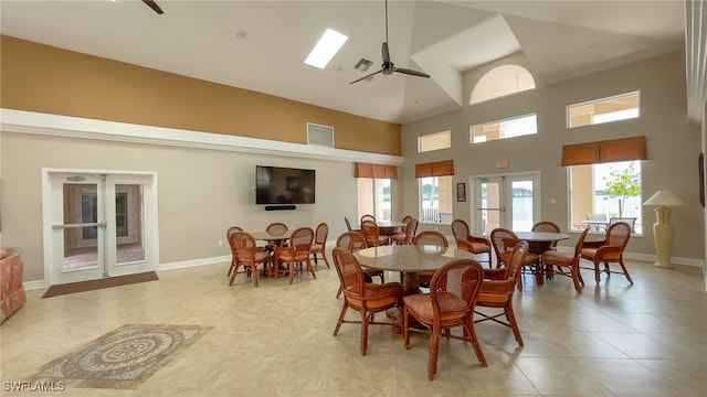 dining space featuring light tile patterned floors, ceiling fan, french doors, and high vaulted ceiling