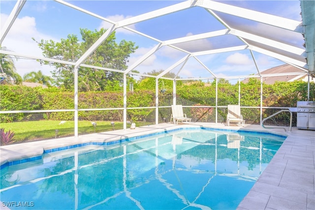 view of swimming pool with glass enclosure and a patio area