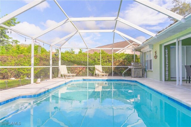 view of swimming pool featuring a patio, glass enclosure, and grilling area