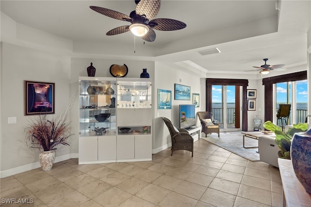 living area featuring a raised ceiling and ceiling fan