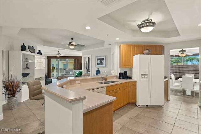 kitchen featuring kitchen peninsula, sink, a raised ceiling, and white appliances