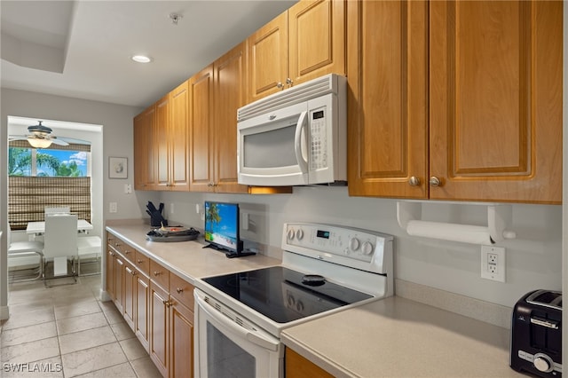 kitchen featuring light tile patterned flooring, white appliances, and ceiling fan