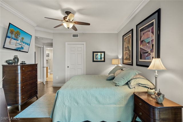 bedroom with ensuite bath, ornamental molding, dark hardwood / wood-style floors, and ceiling fan