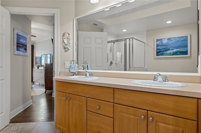 bathroom with a shower with door, vanity, and wood-type flooring