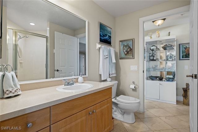 bathroom featuring vanity, a shower with shower door, toilet, and tile patterned flooring