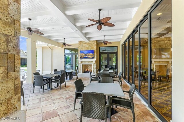 7638 Jacaranda Ln, Naples, FL 34114 - view of patio featuring french doors, outdoor dining area, a large fireplace, and a ceiling fan