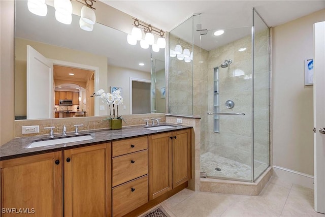 bathroom with decorative backsplash, tile patterned floors, a shower with shower door, and vanity