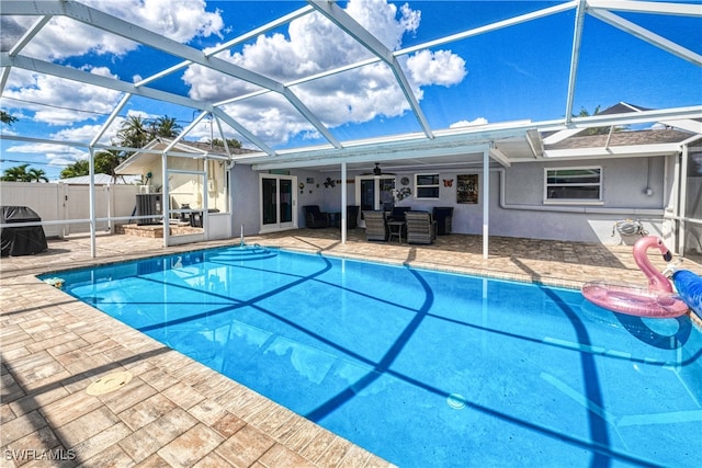 view of pool featuring a lanai, ceiling fan, and a patio area