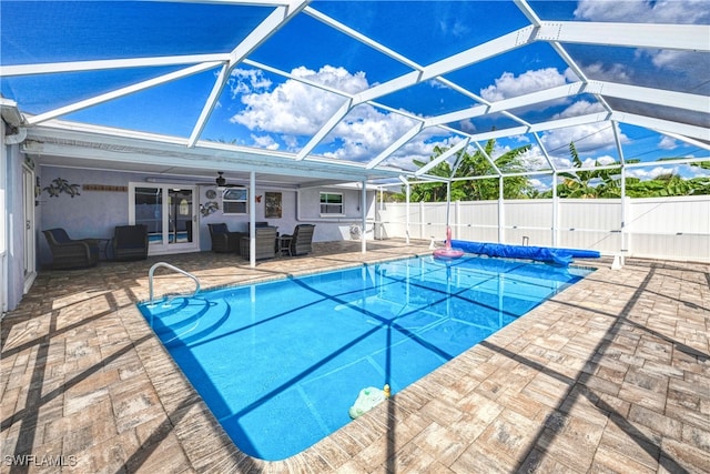 view of pool featuring glass enclosure, ceiling fan, and a patio