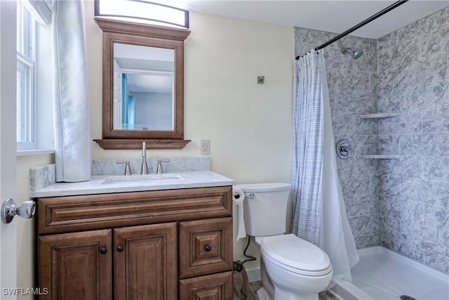 bathroom featuring curtained shower, vanity, and toilet