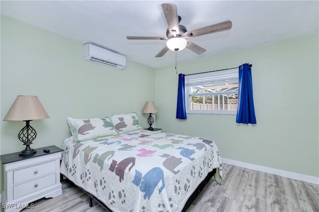 bedroom featuring light wood-type flooring, ceiling fan, and a wall unit AC