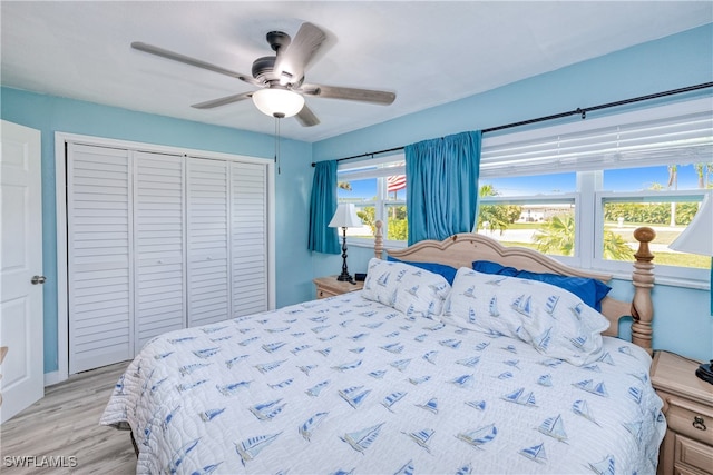 bedroom with light hardwood / wood-style floors, ceiling fan, and a closet