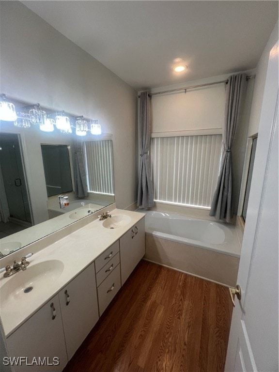 bathroom featuring vanity, a bathtub, and hardwood / wood-style flooring