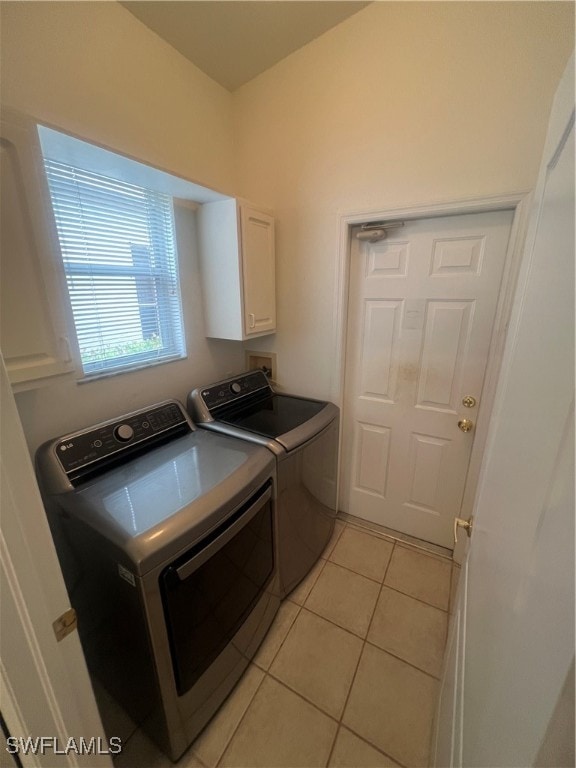 laundry room featuring light tile patterned flooring, independent washer and dryer, and cabinets