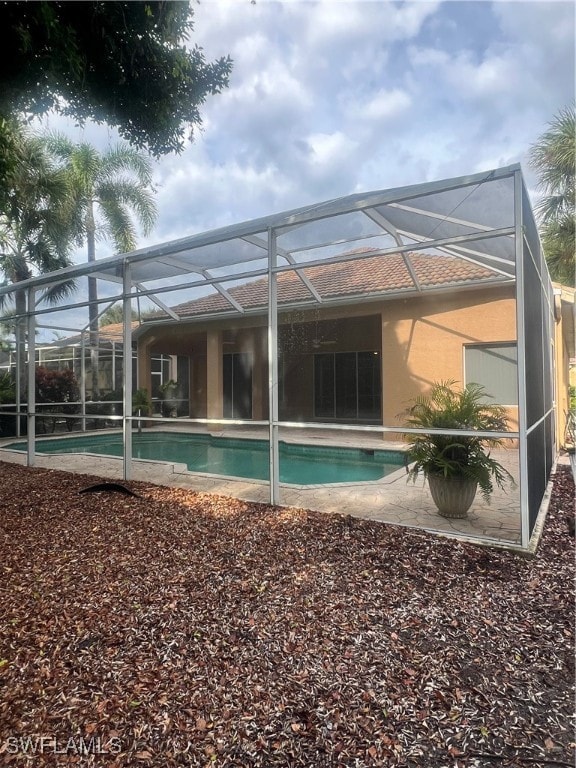 back of house with a patio and a lanai