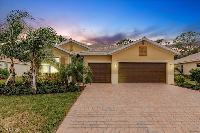 ranch-style house with a yard and a garage