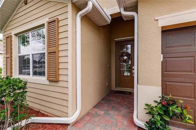 view of exterior entry featuring stucco siding