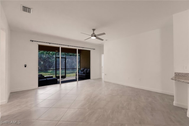 tiled empty room featuring ceiling fan