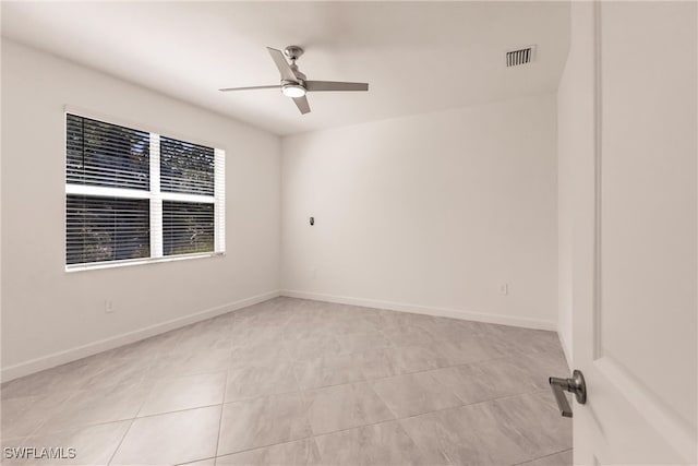 empty room with light tile patterned floors and ceiling fan