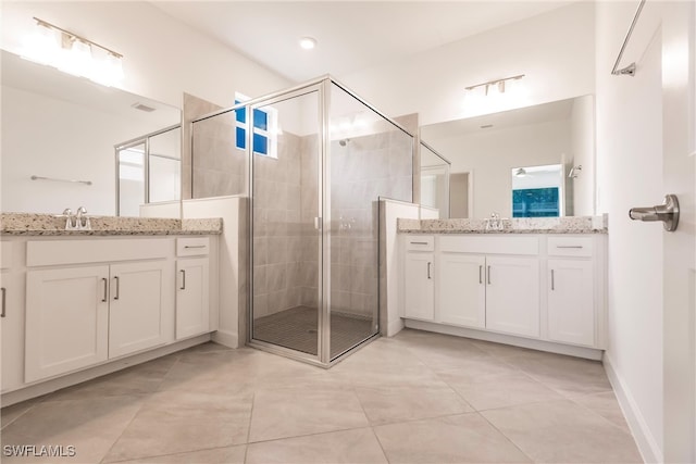 bathroom with vanity, a shower with shower door, and tile patterned floors