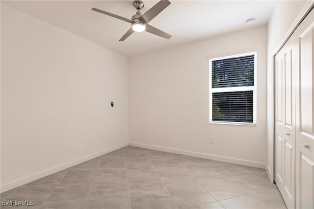 tiled spare room featuring ceiling fan