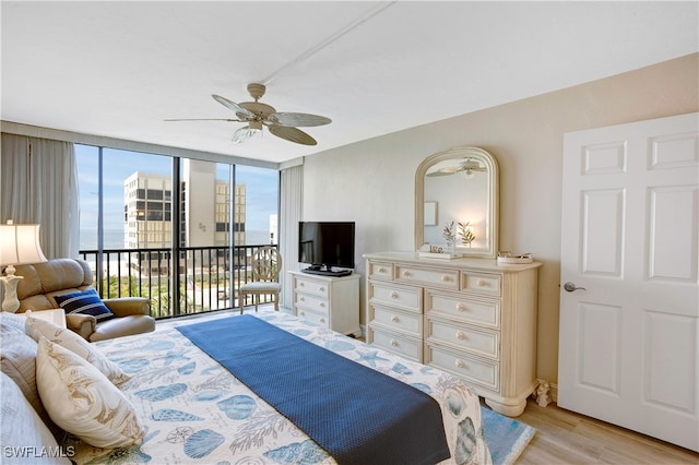 bedroom with access to outside, floor to ceiling windows, light hardwood / wood-style floors, and ceiling fan