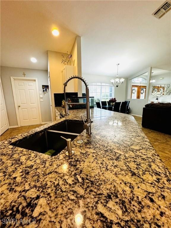 kitchen featuring vaulted ceiling, a notable chandelier, and sink