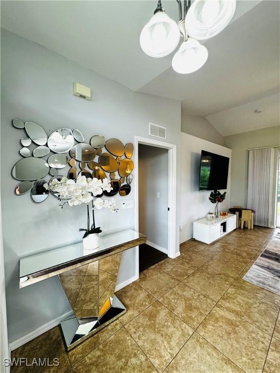 interior space featuring tile patterned flooring and lofted ceiling