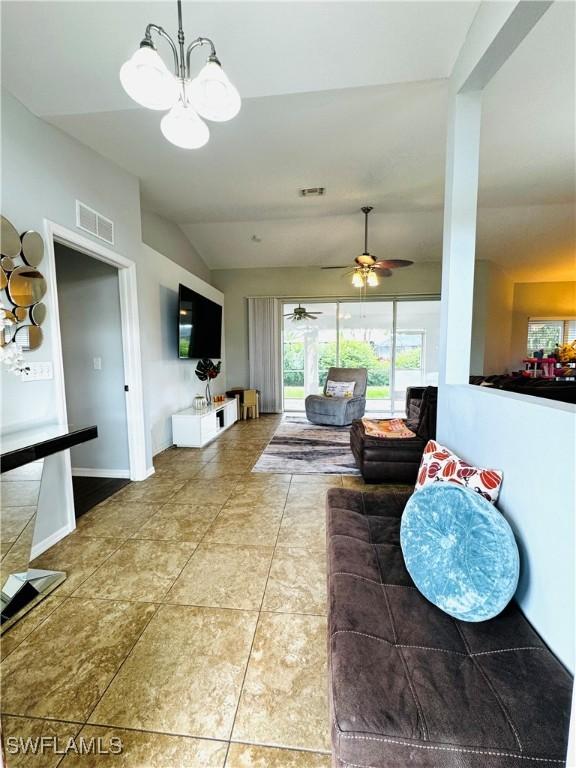 living room with tile patterned flooring, ceiling fan with notable chandelier, and lofted ceiling