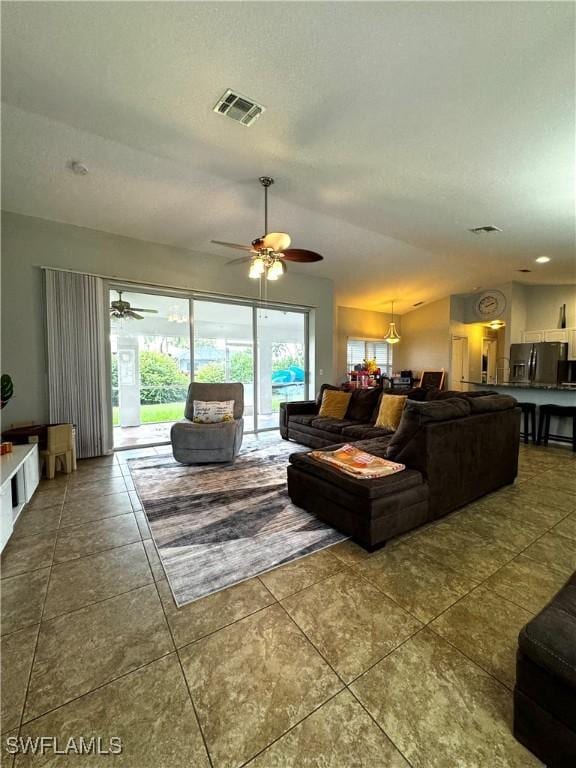 living room featuring tile patterned flooring and ceiling fan