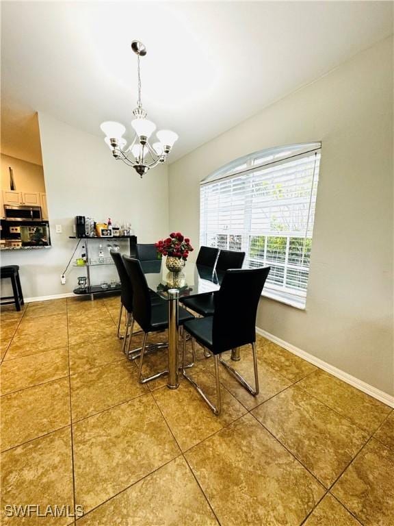 tiled dining space with a notable chandelier