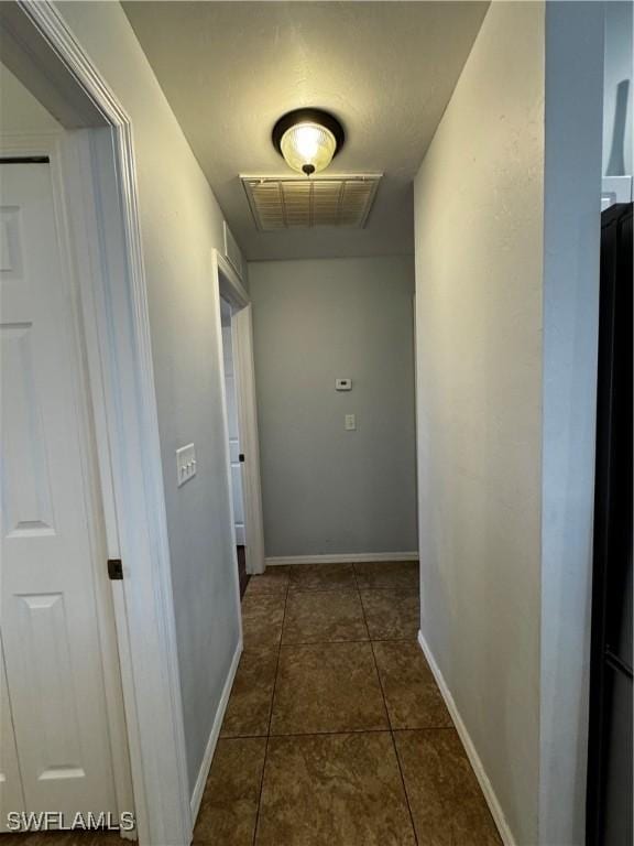 hall featuring dark tile patterned floors