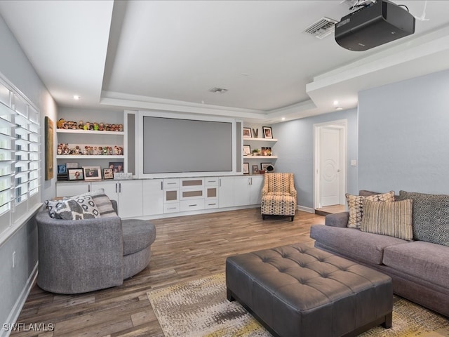 living room featuring a tray ceiling and dark wood-type flooring