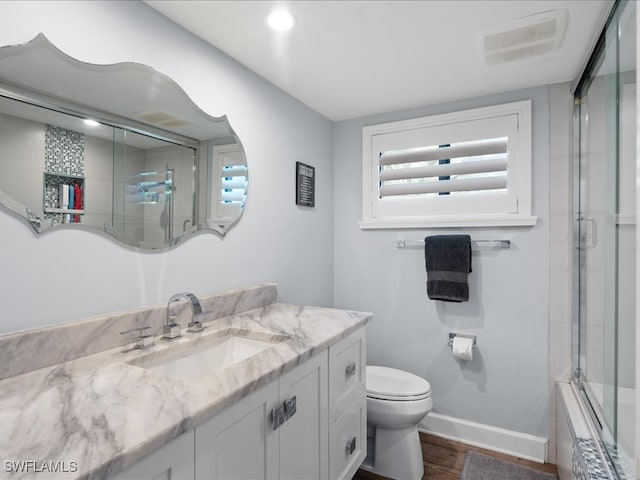 bathroom featuring walk in shower, vanity, hardwood / wood-style floors, and toilet