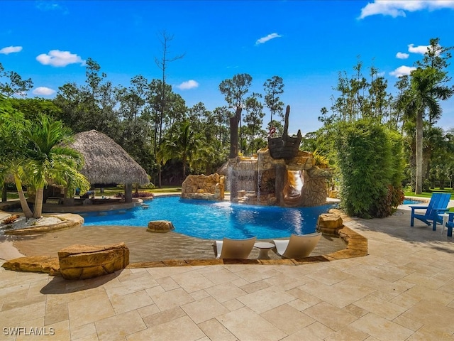 view of swimming pool featuring pool water feature and a patio