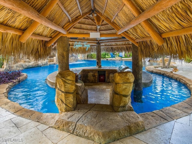 view of pool with a gazebo, pool water feature, and a grill