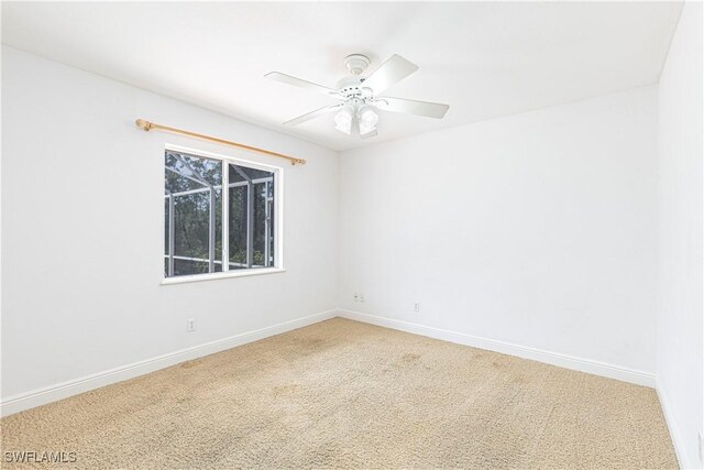 empty room featuring ceiling fan and carpet