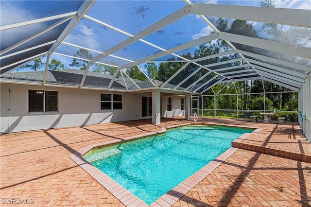 outdoor pool with glass enclosure and a patio area