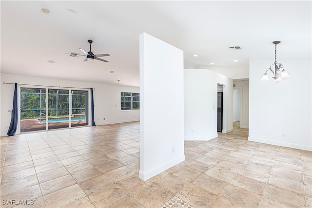 empty room featuring ceiling fan with notable chandelier