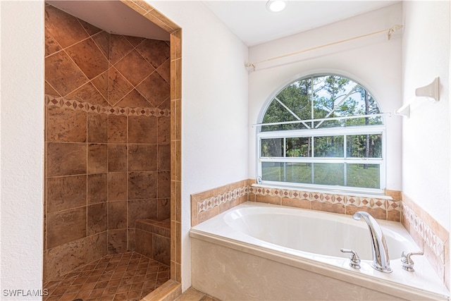 bathroom featuring shower with separate bathtub