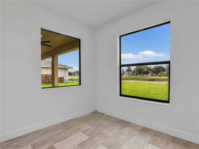 unfurnished room with light hardwood / wood-style flooring and ceiling fan